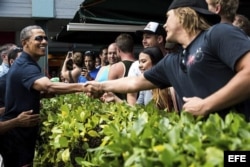 Obama (izda), saluda a varias personas durante un paseo en Kailua, Hawai.