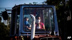 Una familia se traslada en un tractor en las afueras de La Habana, en medio de la crisis sanitaria por el coronavirus. (AP/Ramón Espinosa)