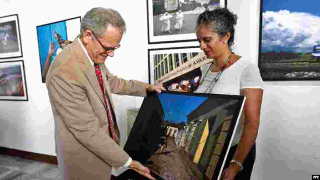 Eliana Aponte, entrega una obra a Jeffrey DeLaurentis, encargado de negocios de la Embajada de EEUU