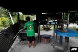 Una residente cocina en la localidad de Arau, en Guyana, este 10 de diciembre. (Roberto Cisneros/AFP)