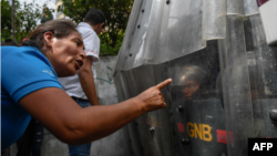 Mujer venezolana, desarmada, reprocha a la guardia madurista preparada para reprimir