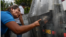 Mujer venezolana, desarmada, reprocha a la guardia madurista preparada para reprimir