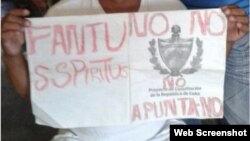 Activista de FANTU sostiene un cartel con la consigna Apunta NO contra el referendo constitucional en Cuba. 