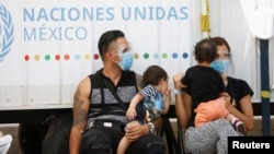 Eduardo Torobo y Amelin Acosta, migrantes de Cuba bajo el programa de Protocolos de Protección al Migrante, esperan en el albergue temporal para migrantes Leona Vicario el 18 de junio de 2021. REUTERS/Jose Luis Gonzalez