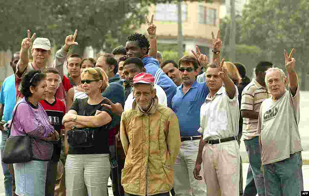 Un grupo de disidentes cubanos levantan sus manos haciendo la "V" de la victoria, mientras permanecen frente a un tribunal penal en La Habana, el 03 de abril de 2003, donde varios disidentes estan siendo juzgados. Casi 80 opositores al régimen comunista d