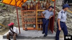 Dos policías observan desde una caseta artesanal, en el poblado El Cobre, Santiago de Cuba. 