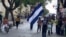 Un joven nicaragüense sostienen una bandera de Nicaragua mientras camina por una calle en San José, el 20 de septiembre de 2021.