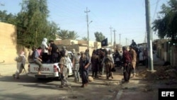 Rebeldes permanecen en una calle de Tikrit, norte de Irak, hoy miércoles 11 de junio de 2014. La ofensiva sobre el norte de Irak de los insurgentes suníes, encabezados por el Estado Islámico de Irak y el Levante (EIIL), cobró hoy un nuevo impulso con su e