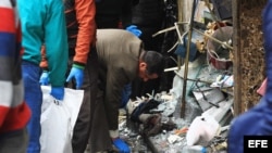 Personal de seguridad investiga la escena de la explosión de una de las bombas, en la catedral de San Marcos, en Alejandría.