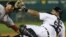 El receptor de Tigres Brayan Peña (d) choca con el árbitro de tercera base Rob Drake (i).