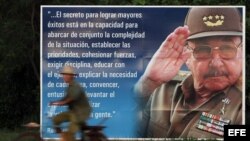 Un campesino pasea en bicicleta junto a un cartel con la imagen de Raúl Castro. 