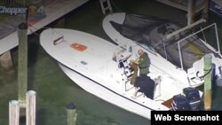Las autoridades revisan el bote en el que arribaron los migrantes. (Captura de video/CBS Miami)