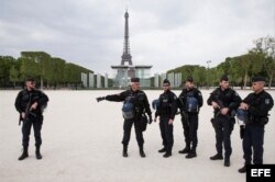 La policía parisina patrulla los Champs de Mars frente a la Torre Eiffel.