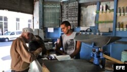 Un bodeguero vende productos racionados a un cliente en La Habana. (Archivo)