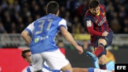 Leo Messi golpea el balón ante los defensores de la Real Sociedad