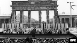 Fotografía de archivo del 12 de junio de 1987 que muestra al por entonces presidente de Estados Unidos Ronald Reagan (c) y al canciller alemán Helmut Kohl (a la derecha de Reagan) durante una ceremonia en el lado oeste del Muro de Berlín (Alemania), frent