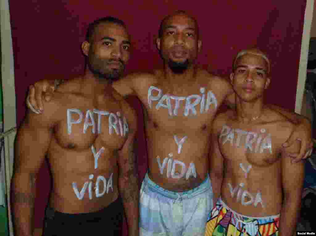 El activista Osmani Pardo Guerra junto a su hermano y su primo con el t&#237;tulo de la canci&#243;n &quot;Patria y Vida&quot; escrito en el cuerpo.