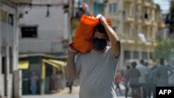 Un residente de La Habana carga una bolsa con alimentos el 17 de abril del 2020.