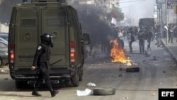 Un policía egipcio mira a manifestantes en El Cairo