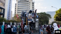 Un grupo de personas observa un quisco de los trabajadores del metro de Caracas