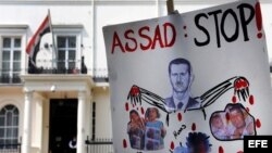 Un cartel anti presidente sirio Bachar al Asad frente a la embajada siria en Londres, Inglaterra, como protesta por la matanza de civiles el pasado viernes en la ciudad siria de Hula. 