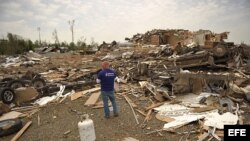 Unos hombres recuperan pertenencias en medio de los escombros en Mayflower R.V. Park tras el paso de un tornado que azotó este, 27 de abril, en Mayflower, Arkansas (EEUU).