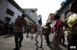 Personas afines al Gobierno cubano bailam y mantienen rodeada la sede de las Damas de Blanco y les impide asistir a la iglesia para celebrar el día de la virgen de "La Merced", patrona de los presos.