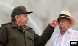 Raúl Castro bromea con el vicepresidente, José Ramón Machado (i-d), durante el desfile por el Día de los Trabajadores en La Habana.