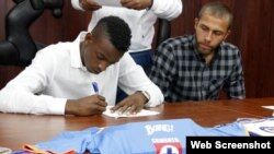 Maykel Reyes firma el contrato con el club mexicano Cruz Azul, mientras Abel Martínez espera su turno.