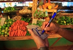 Un vendedor prepara una nueva tablilla de precio para sus productos en un mercado de La Habana. (REUTERS/Stringer)