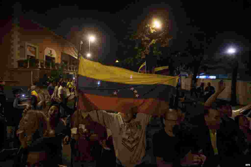 Varias personas celebran la victoria obtenida por la coalición opositora Mesa de Unidad Democrática (MUD), lunes 7 de diciembre de 2015, en la ciudad de Caracas (Venezuela). 