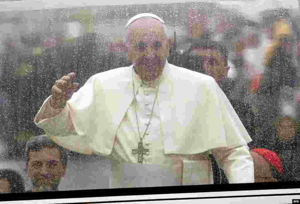 El papa Francisco (c) saluda a fieles durante su recorrido al Santuario Nacional de Nuestra Señora de Aparecida hoy, 24 de julio de 2013, en la ciudad de Aparecida, a 196 kilómetros de Sao Paulo (Brasil). El pontífice oficiará hoy su primera misa en Brasil a donde llegó el pasado 22.