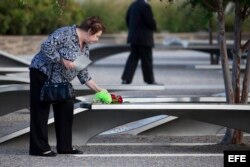 Una mujer deposita flores en homenaje a las víctimas del 9/11 en el Pentágono.