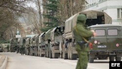 Hombres armados no identificados en uniforme militar bloquean una base militar ucraniana.