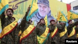 Miembros de HizbAlláh saludan durante el funeral de Alí Fayyad, uno de sus comandantes