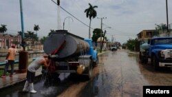 Un conductor se refresca mientras llena el tanque de una pipa de agua en La Habana, el 3 de julio de 2023. La población afectada por este servicio vital aumentó de 78 mil personas, en 2022, a 114 mil en 2023. REUTERS/Alexandre Meneghini