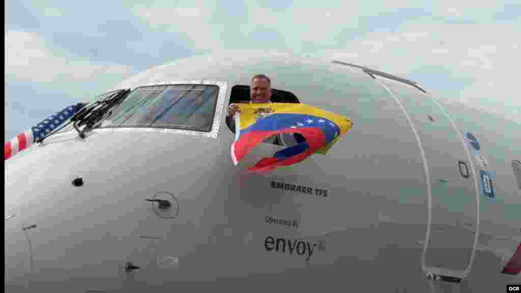 El piloto del vuelo de American Airlines celebra la reanudación de la ruta directa entre Miami Caracas agitando la bandera de Venezuela desde la cabina del avión. 