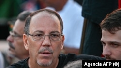Alejandro Castro Espín (izq.), hijo de Raúl Castro —quien ha sido acusado formalmente por un tribunal estadounidense—, asiste a un acto de apoyo a este frente a la Embajada de Estados Unidos en La Habana, el 22 de mayo de 2026. ADALBERTO ROQUE / AFP
