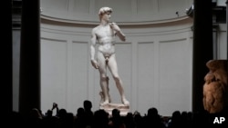 Visitantes se agolpan alrededor de “David”, la estatua de mármol blanco de Miguel Ángel en la Galería de la Academia en Florencia, Italia, 28 de marzo de 2023. (AP Foto/Alessandra Tarantino)