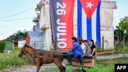 Residentes se trasladan en una carretón de caballos ante la falta de transporte urbano la ciudad de Pinar del Río, cede este año del acto central por el 26 de Julio. 
