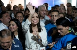 La aspirante presidencial de la oposición María Corina Machado, centro, celebra con sus partidarios tras resultar ganadora de las elecciones primarias de la oposición. (Foto AP/Ariana Cubillos )