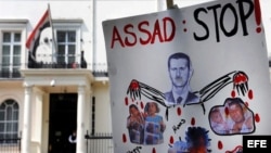 Un cartel anti presidente sirio Bachar al Asad frente a la embajada siria en Londres, Inglaterra, como protesta por la matanza de civiles el pasado viernes en la ciudad siria de Hula. 