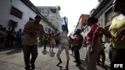 Personas afines al Gobierno cubano bailan y mantienen rodeada la sede de las Damas de Blanco y les impiden asistir a la iglesia para celebrar el día de la virgen de "La Merced", patrona de los presos.