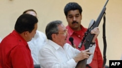 Raúl Castro muestra el rifle de su hermano Fidel Castro al entonces presidente de Venezuela Hugo Chávez, y a su predecesor, Nicolás Maduro, en Santiago de Cuba, en diciembre de 2007. 