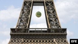 Una bola de tenis gigante con las palabras "Roland Garros" cuelga de la Torre Eiffel de París, Francia.