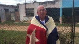 Félix Navarro posa arropado por una bandera cubana.