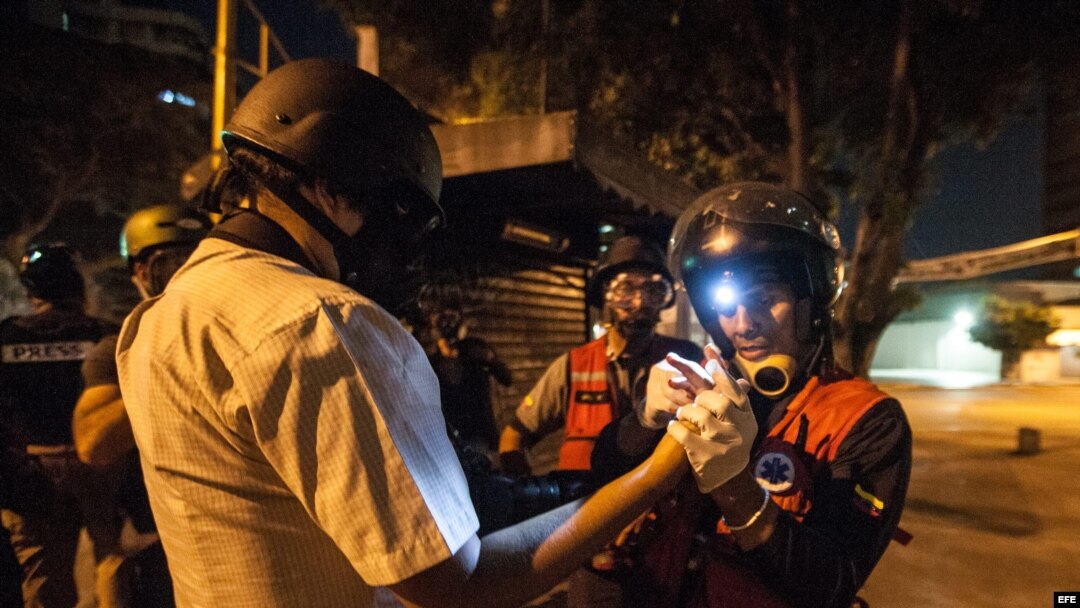 Un fotógrafo de la agencia Efe en Venezuela es atendido por por integrantes del grupo de rescate "Antonio José de Sucre" luego de sufrir heridas por el impacto de perdigones.