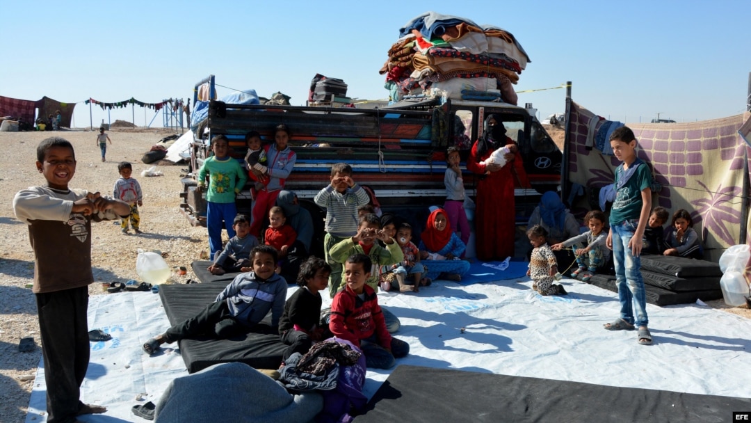 Familias sirias desplazadas que huyeron de las ciudades de Deir Ezzor y Al-Raqqa ocupadas por el Estado Islámico (IS), se sientan en un campamento de refugiados de Ghana, en la provincia sureña de Hasakah, Siria, 11 de octubre de 2017. El número de despla