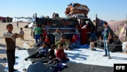 Familias sirias desplazadas que huyeron de las ciudades de Deir Ezzor y Al-Raqqa ocupadas por el Estado Islámico (IS), se sientan en un campamento de refugiados de Ghana, en la provincia sureña de Hasakah, Siria, 11 de octubre de 2017. El número de despla