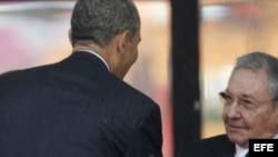 El presidente Barack Obama saluda a Raúl Castro en el servicio religioso por la muerte de Nelson Mandela.